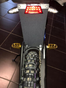Rear light and turn signal holder under the seat on Sur-Ron L1e